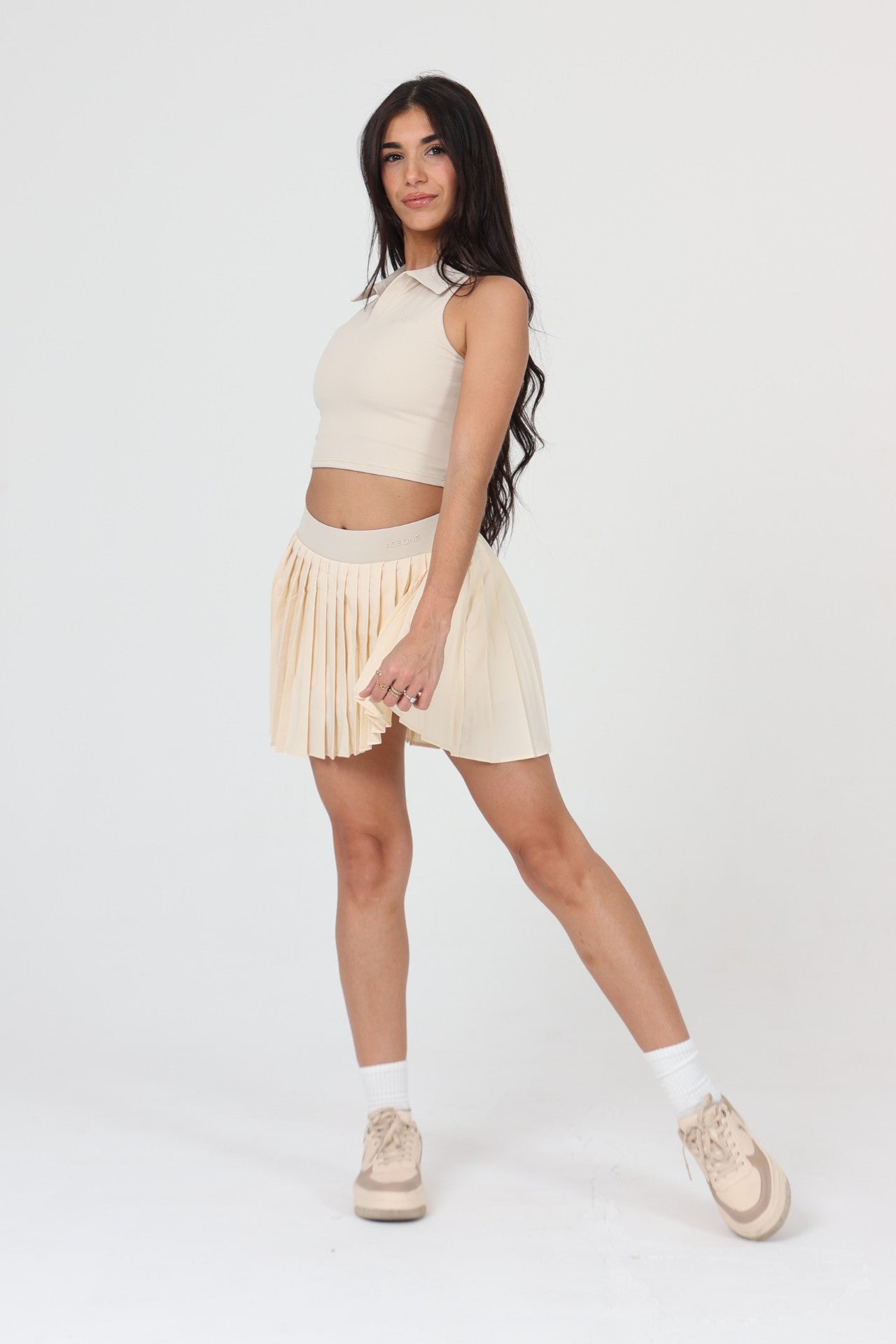 Femme cherchant un lob en jupe plissée padel ACE ONE beige