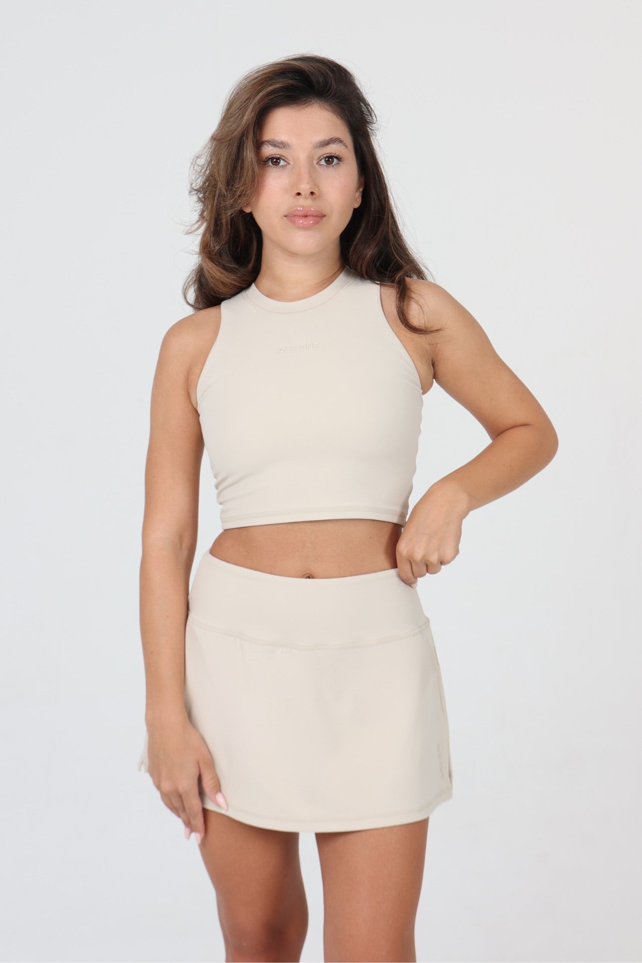 Femme portant le débardeur padel col haut ACE ONE beige court extérieur