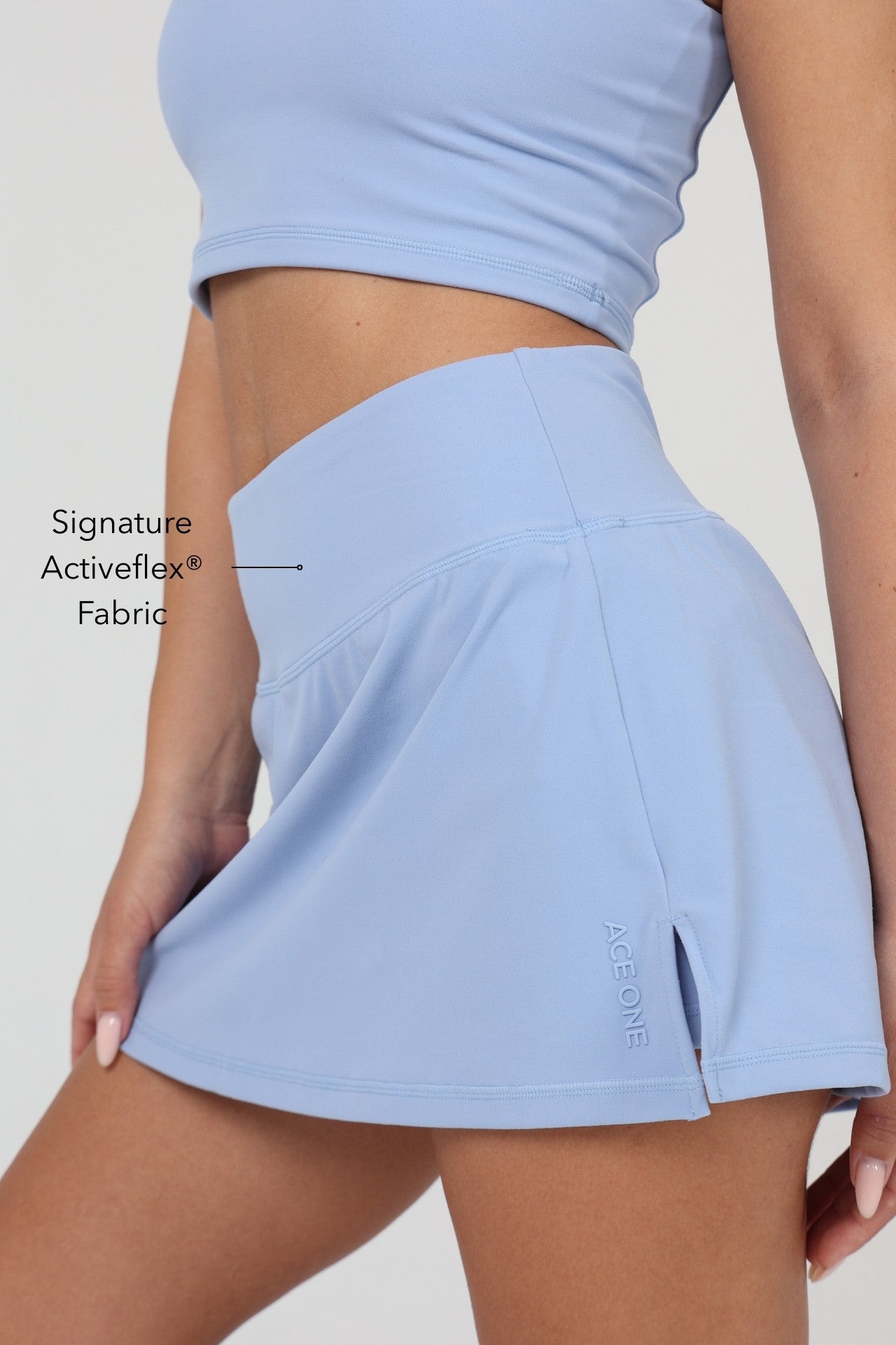 Femme portant le skort padel ACE ONE bleu sur le court