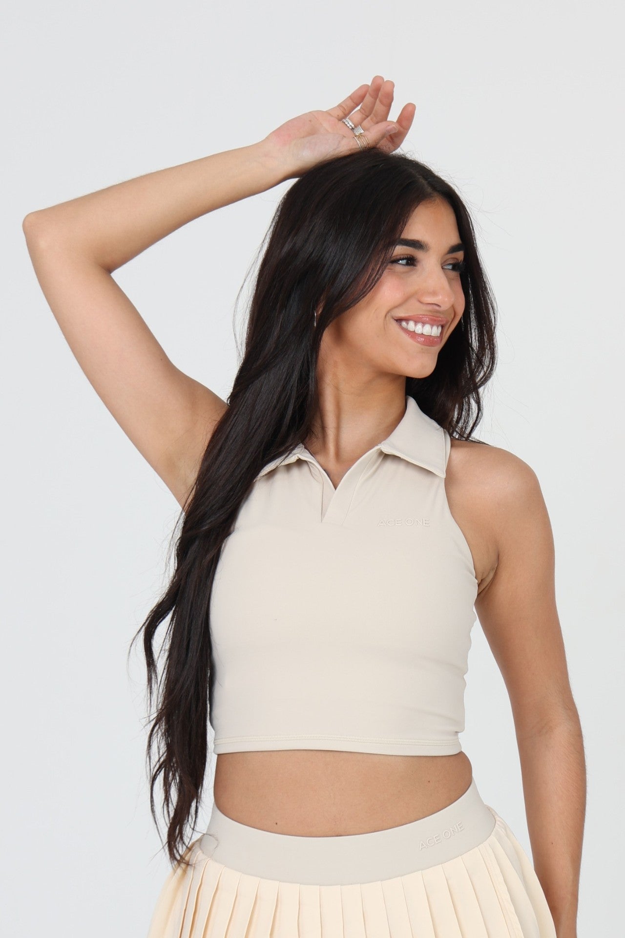 Femme portant le débardeur padel ACE ONE beige sur le court