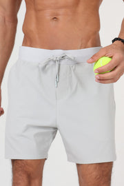 Homme portant le short padel ACE ONE gris sur le court