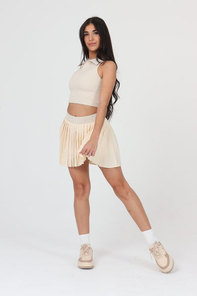 Femme cherchant un lob en jupe plissée padel ACE ONE beige
