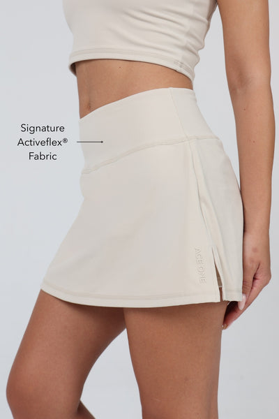 Femme portant le skort padel ACE ONE beige sur le court